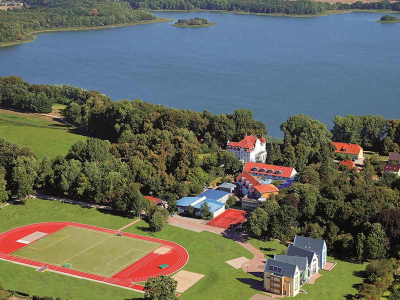 Luftaufnahme vom Internatsgelände Schloss Torgelow mit Gebäuden, Fußball- und Tennisplatz