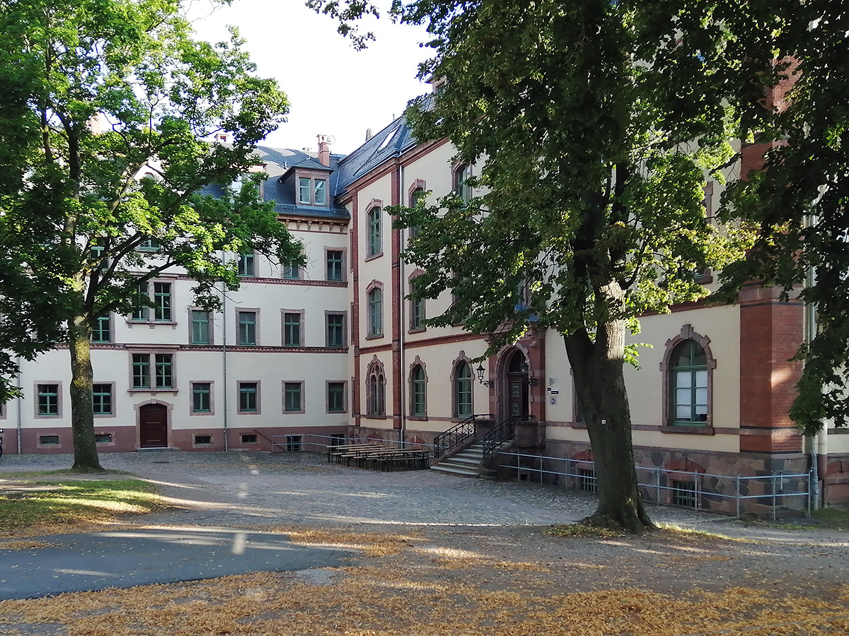 Innenhof eines alten Gebäudes mit Bäumen.