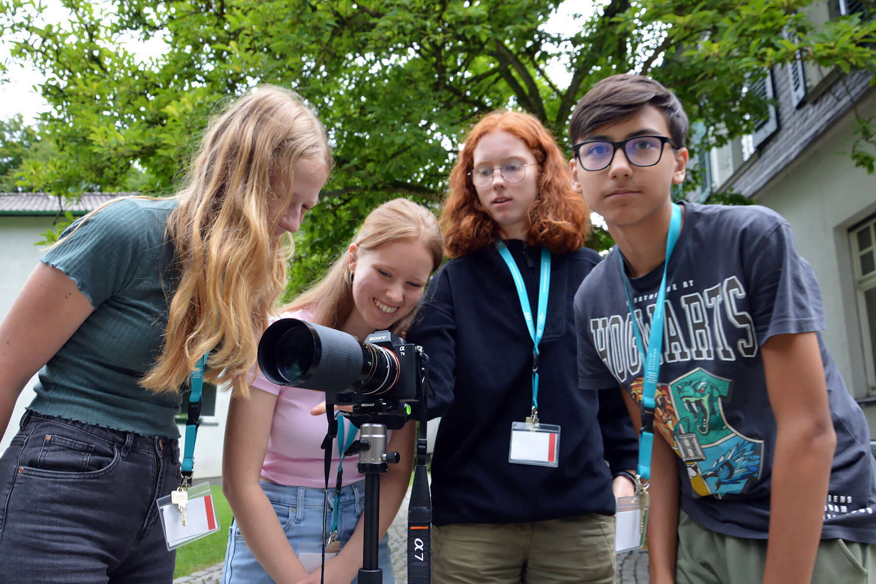 Vier Jugendliche schauen gemeinsam in eine Kamera.