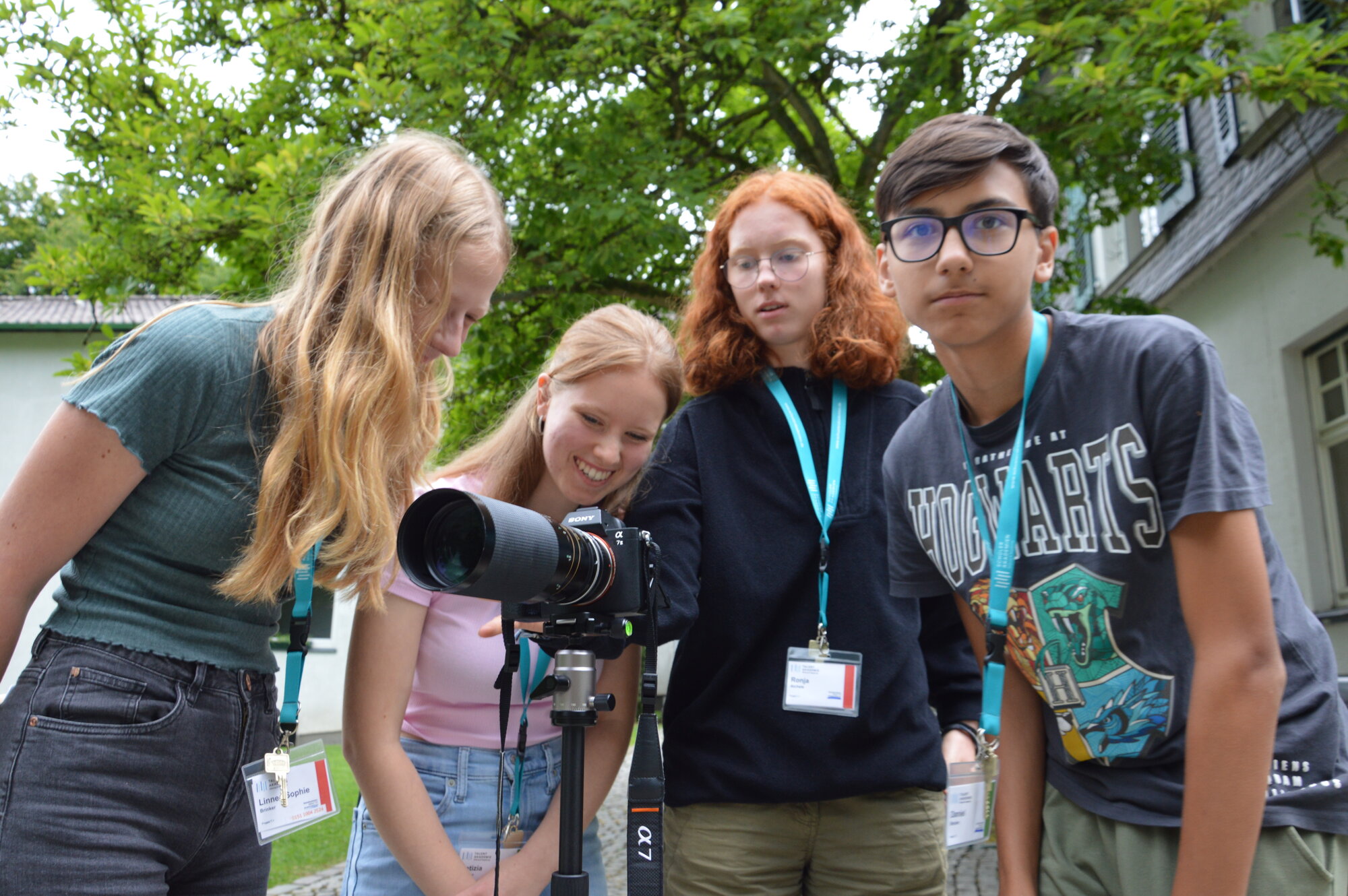 Vier Jugendliche schauen gemeinsam in eine Kamera.