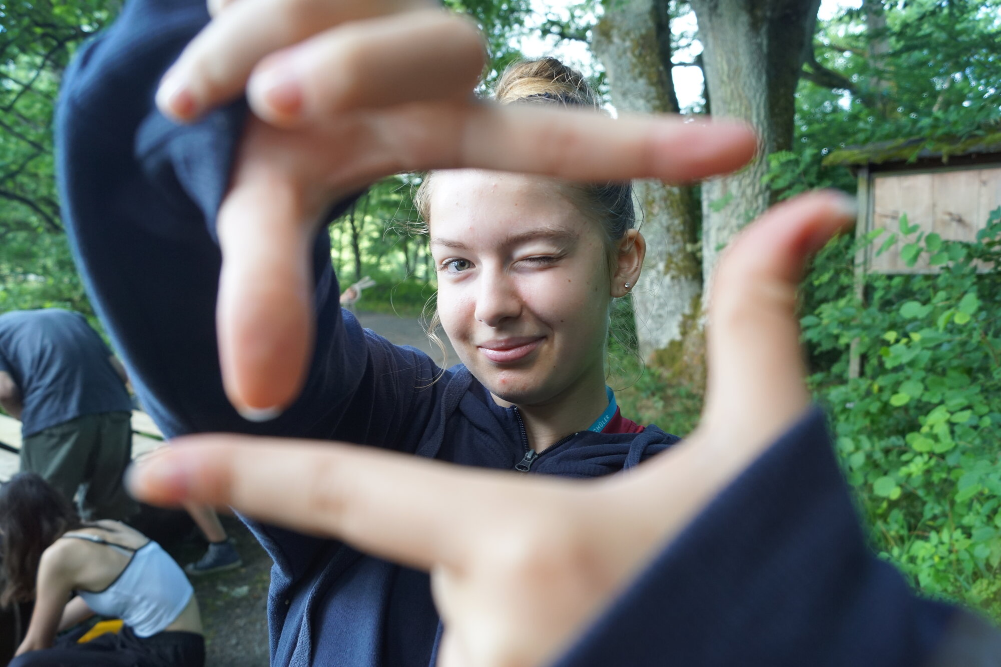 Eine Jugendliche hält ihre Hände zum Zukunftsfenster und blickt hindurch.