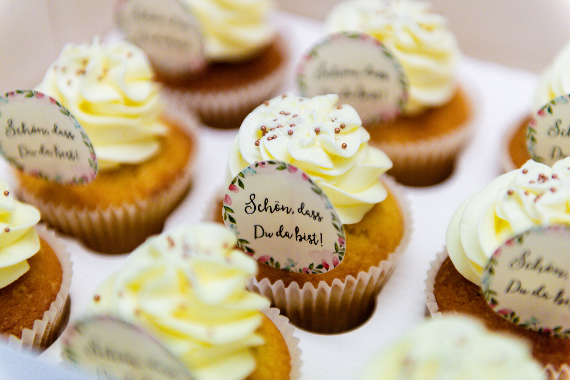 Weißgelbe Cupcakes mit einem Schildchen 